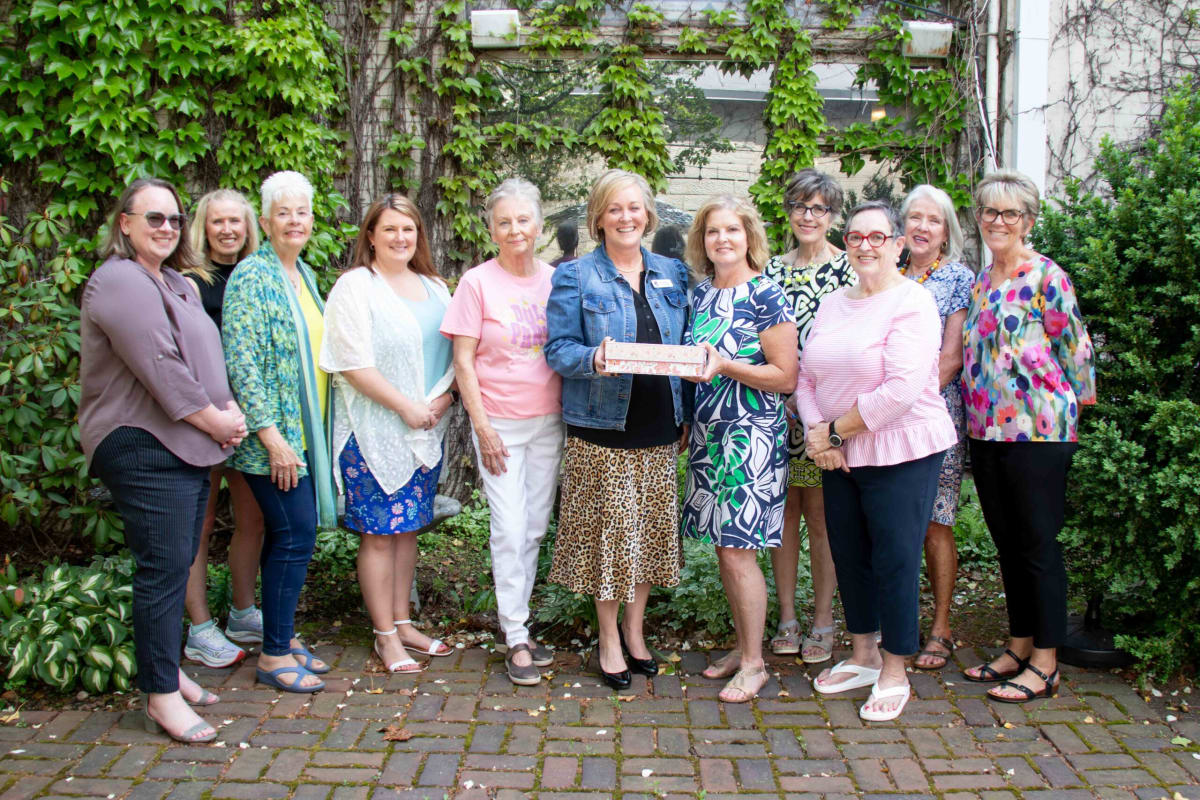 Women holding children's book at donation ceremony for Dolly Parton Imagination Library program