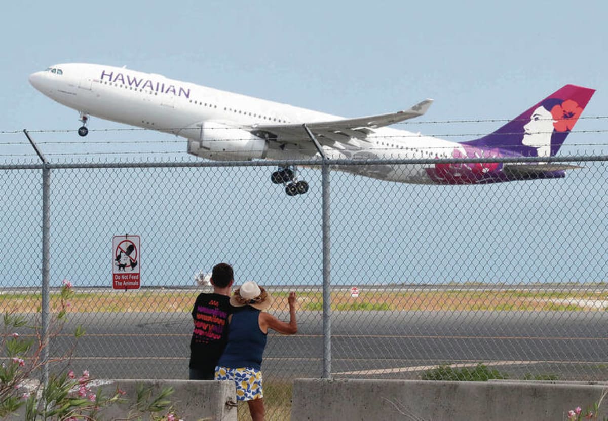 Aerial view of Hawaii airport terminal with aircraft on tarmac under blue sky