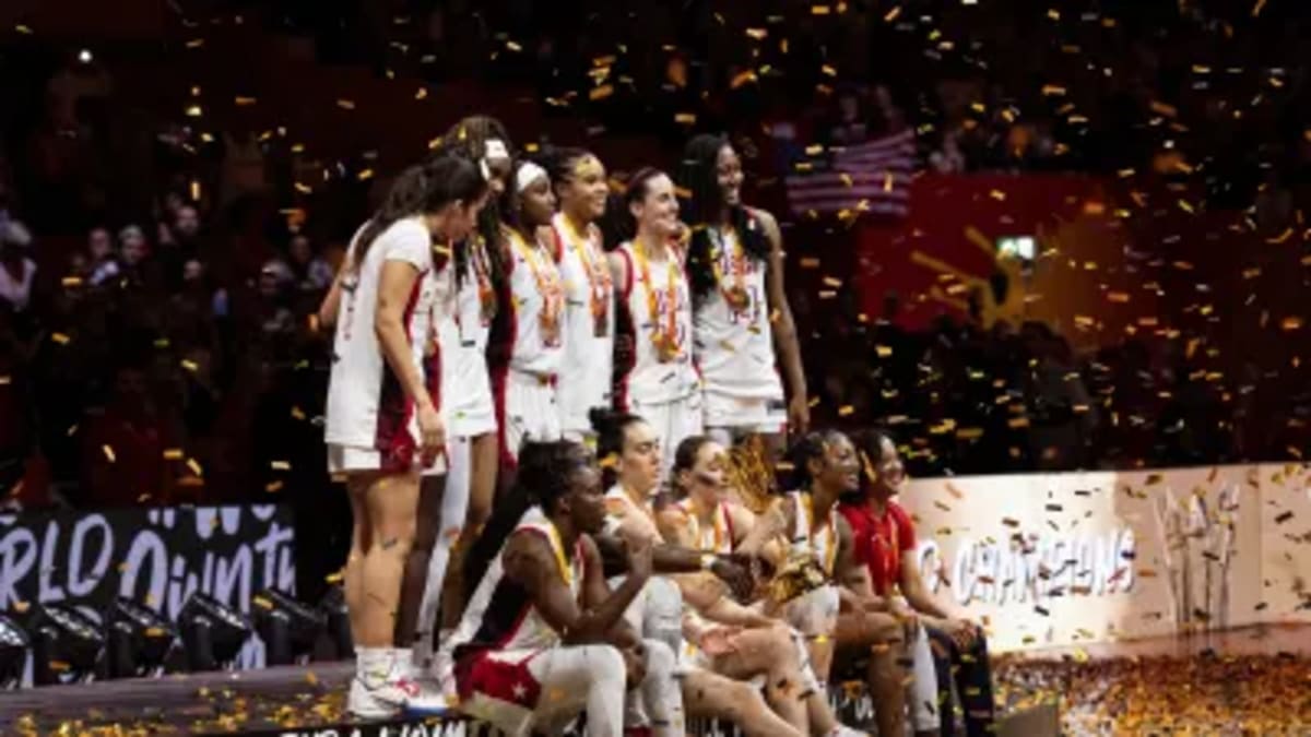 Breanna Stewart celebrating with Team USA teammates holding FIBA World Cup trophy in Berlin