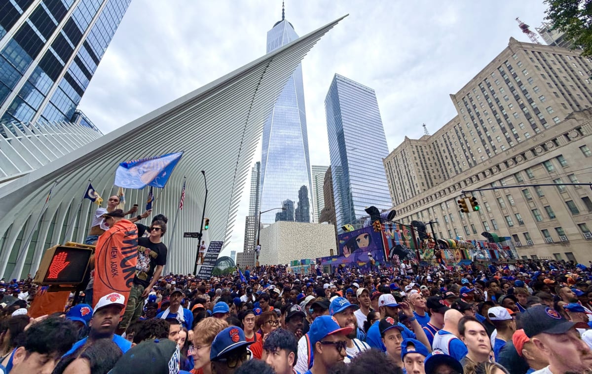 Massive crowd of New York Knicks fans wearing blue and orange celebrating championship parade in Manhattan streets