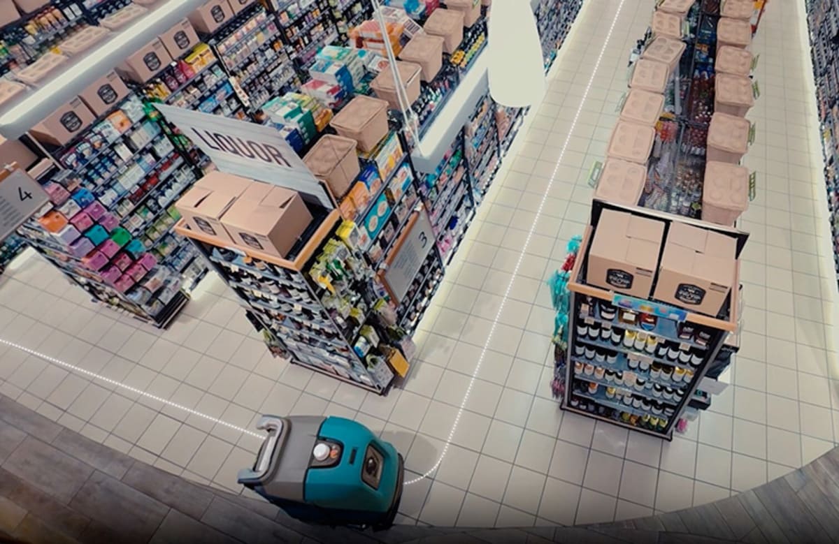 Autonomous floor-cleaning robot navigating warehouse aisle using AI-powered visual sensors and navigation technology