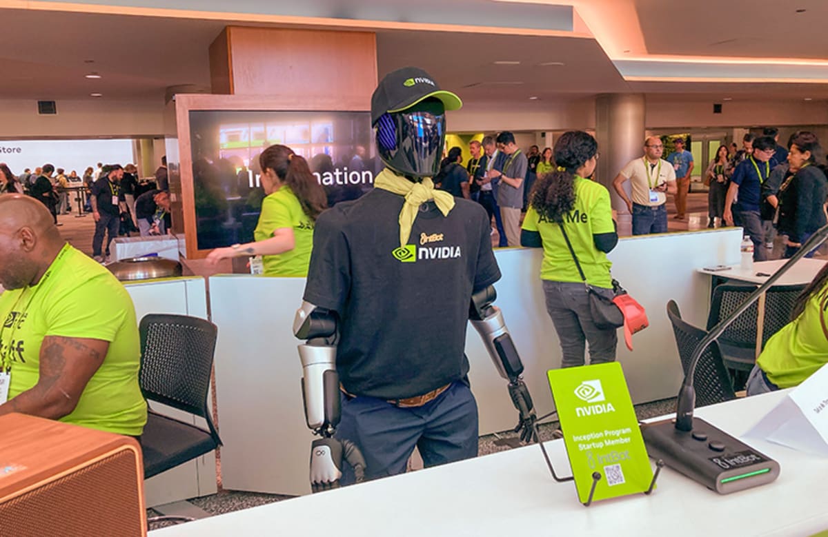 Humanoid robot Nylo standing at help desk greeting conference attendees with natural posture