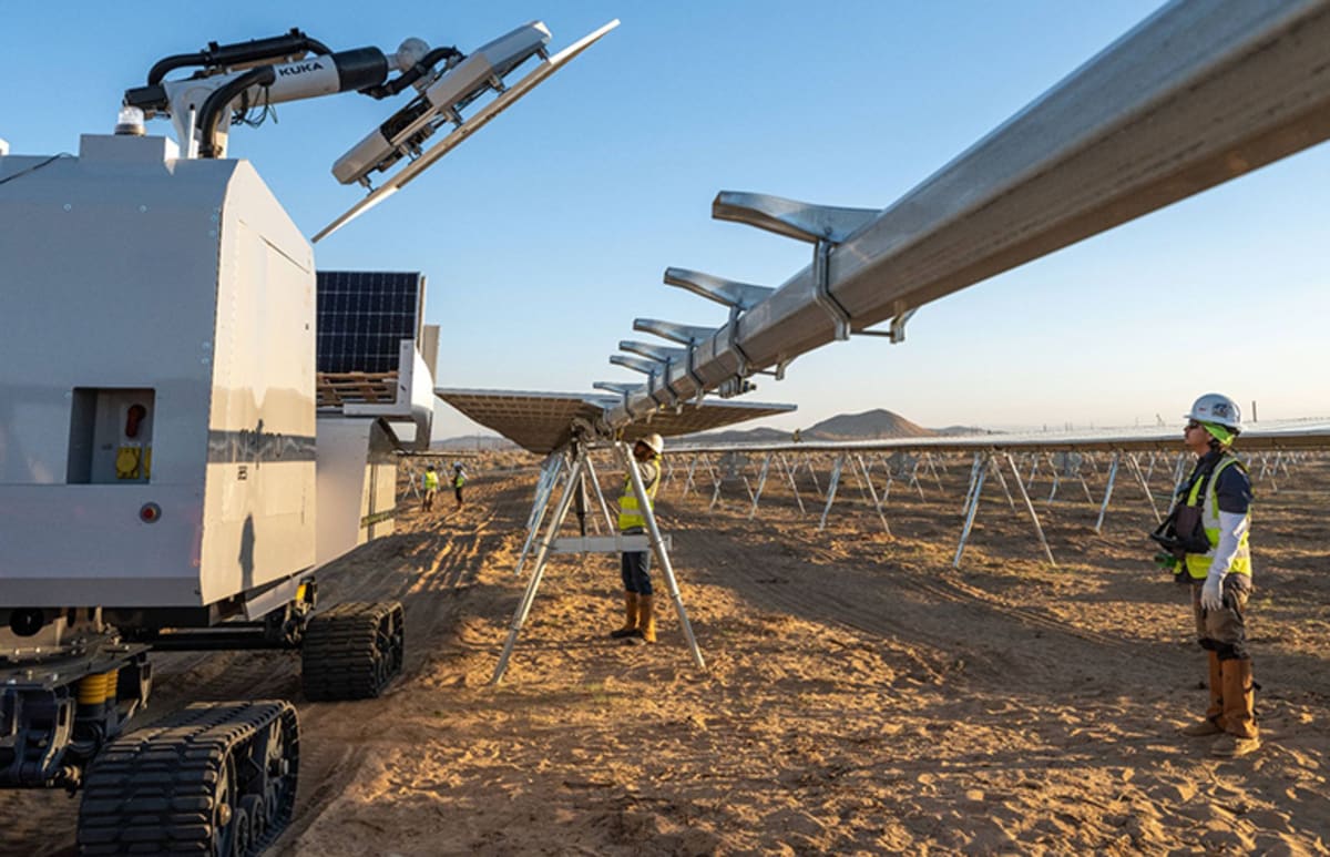 Robotic arm precisely placing large solar panel onto mounting structure at utility scale solar farm