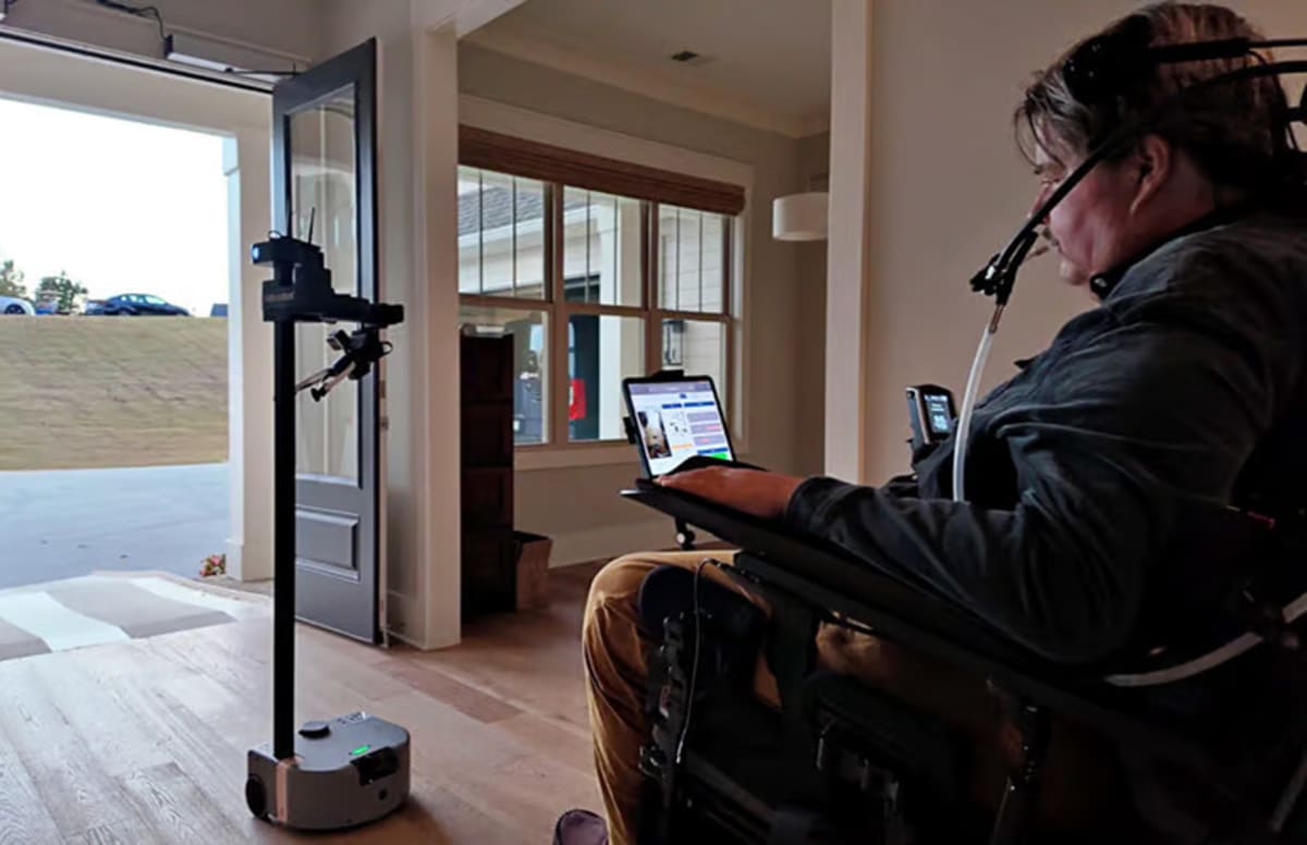 Stretch robot assisting user Keith at home after spinal cord injury, demonstrating mobile manipulation capabilities