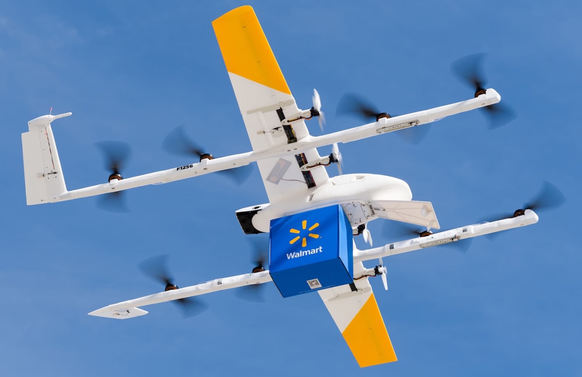 Wing drone hovering above suburban home lowering package on tether to driveway