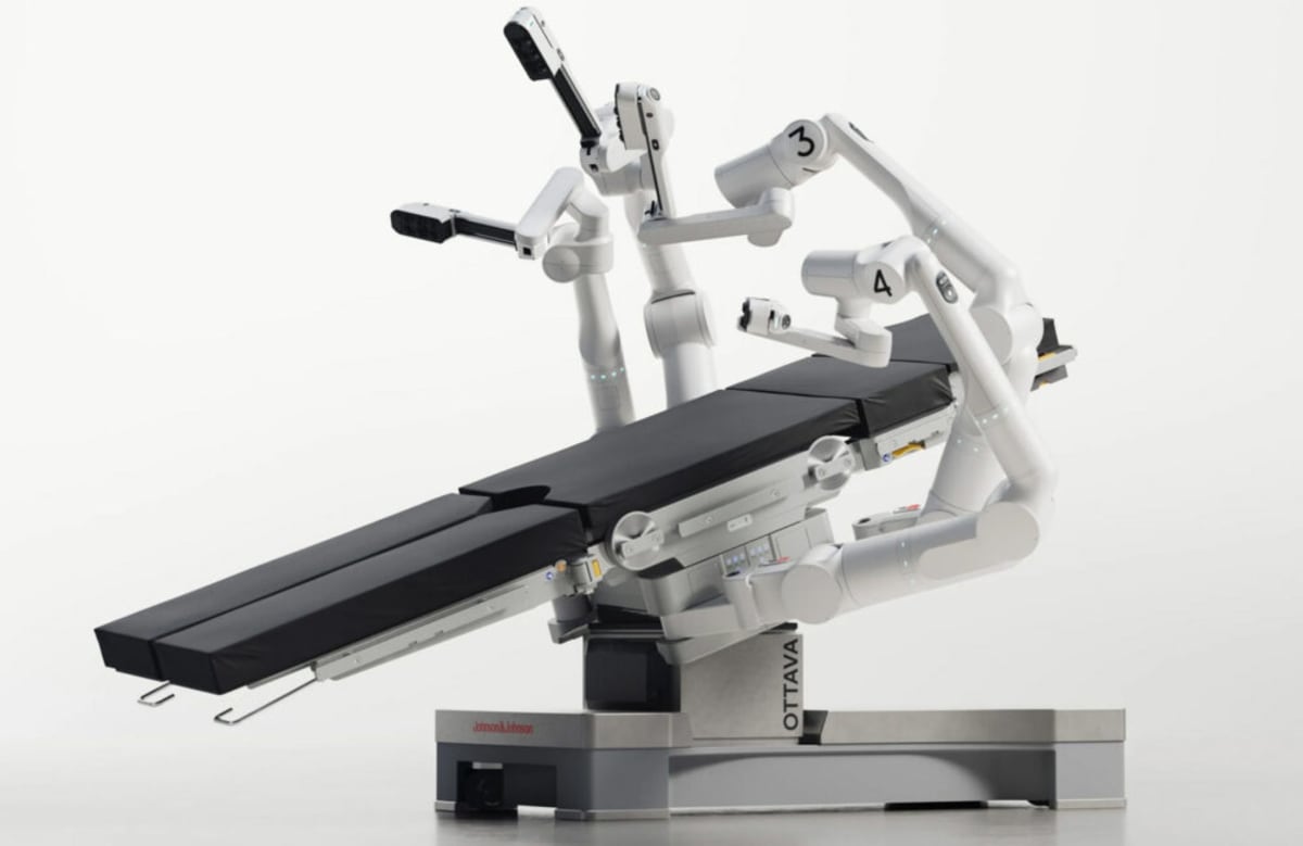 Four robotic surgical arms emerging from beneath an operating table in Johnson & Johnson's Ottava system