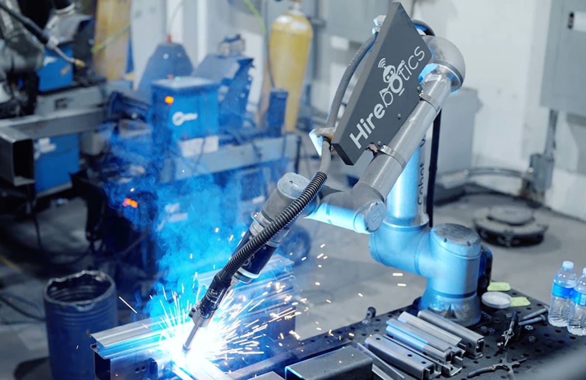 Collaborative welding robot working alongside human operator in modern manufacturing facility