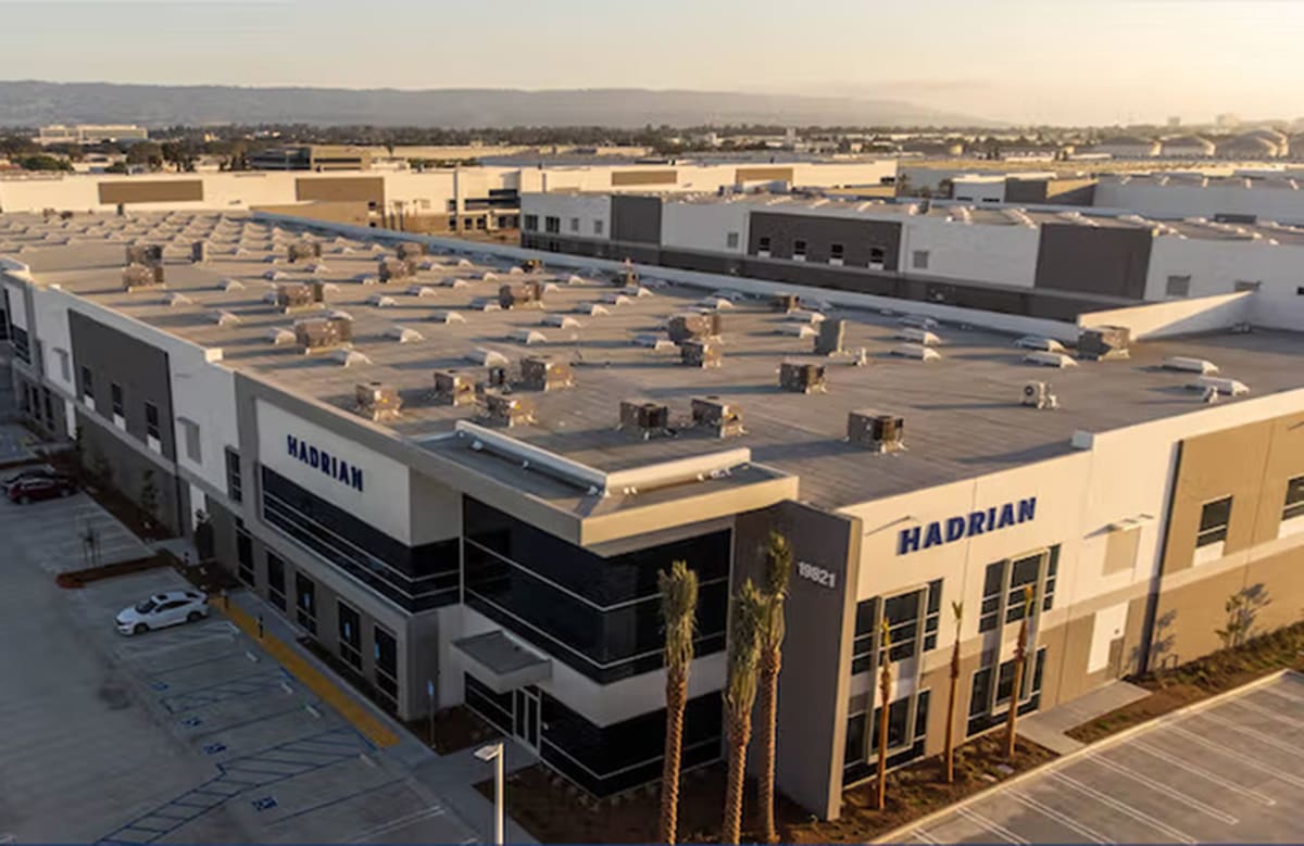 Modern automated factory floor with robotic systems and advanced manufacturing equipment at Hadrian facility