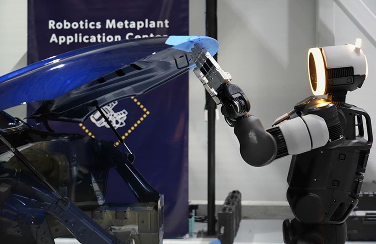 Atlas humanoid robot practicing automotive part handling tasks in training facility