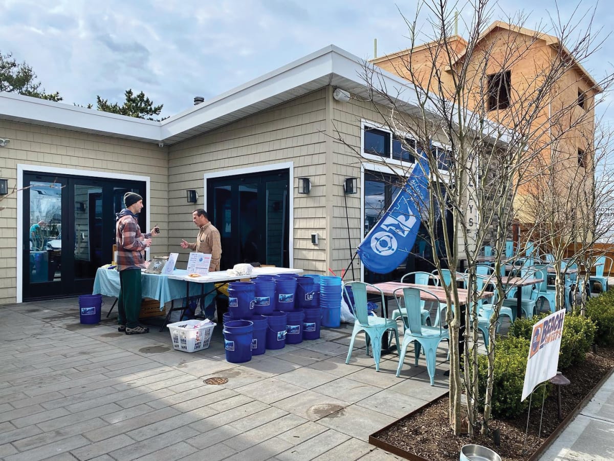 Volunteers wearing gloves collect plastic debris and litter from sandy New Jersey beach