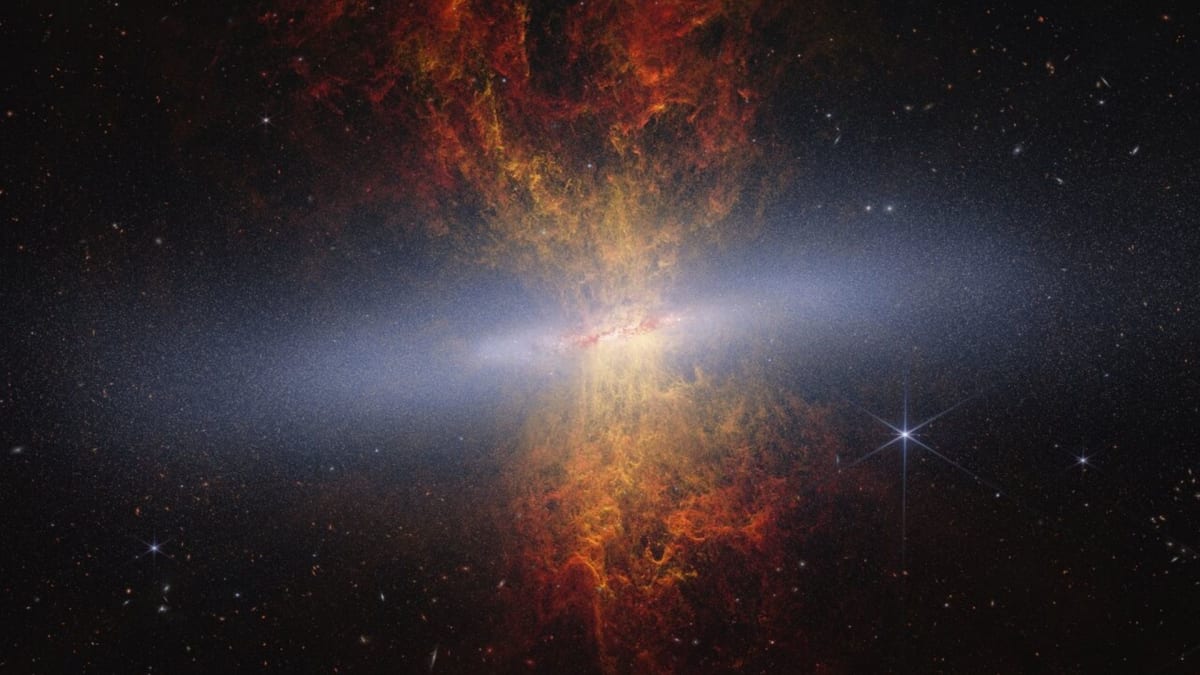 James Webb telescope image showing the Cigar Galaxy with colorful gas clouds forming hourglass shape