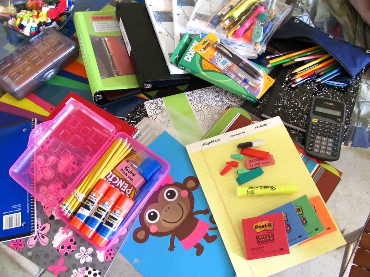 School supplies including colorful backpacks notebooks and pencils arranged for donation collection