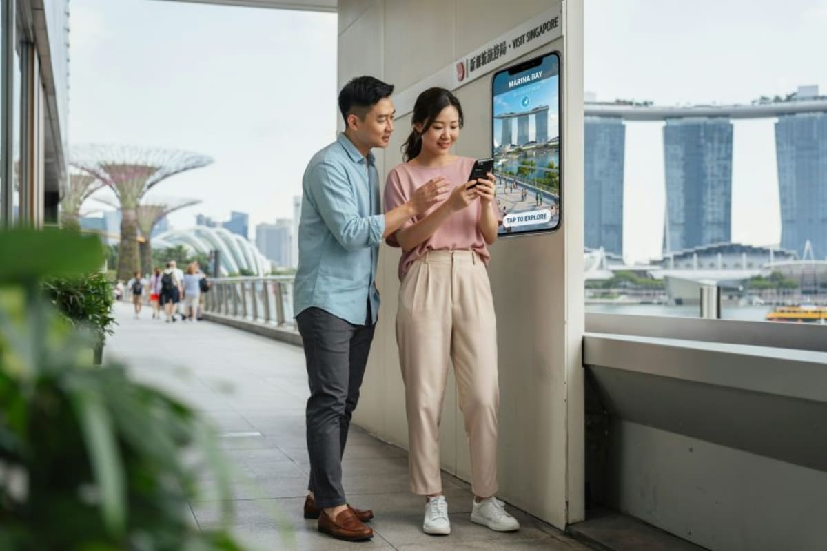 Tourist using smartphone with digital map interface showing Singapore landmarks and local recommendations