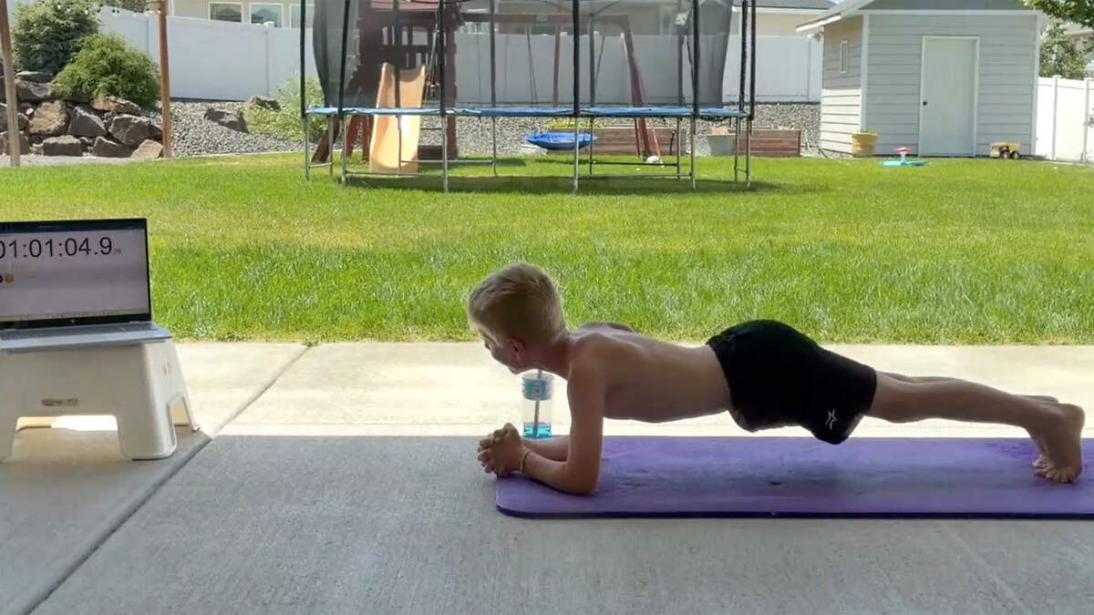 Young boy Jack Sims in plank position on elbows and toes during record attempt