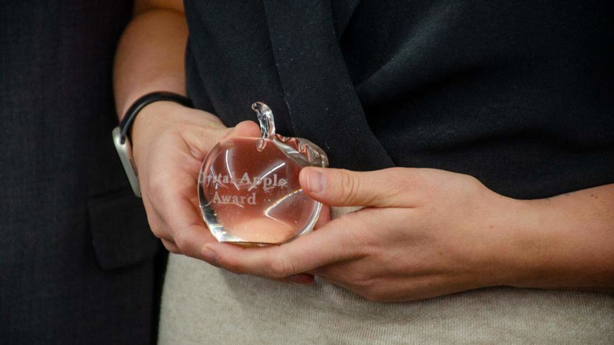 Teacher receiving glass apple trophy at Crystal Apple Awards ceremony in Pasco, Washington
