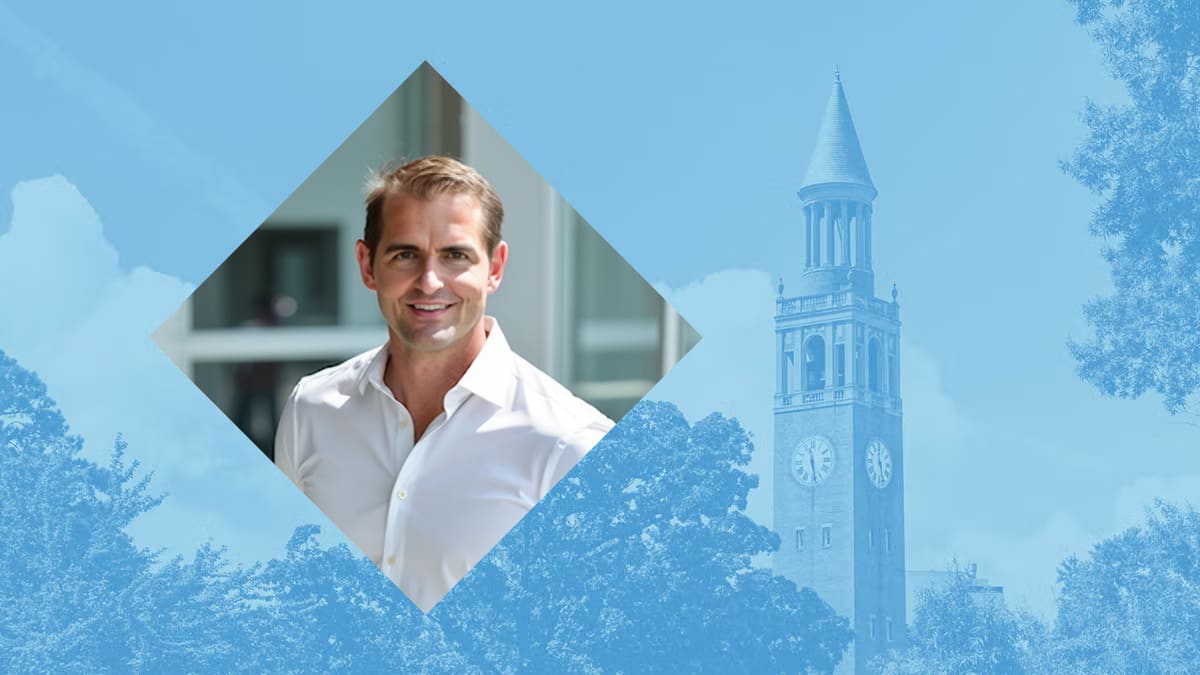 Tommy Sowers smiling at University of North Carolina Chapel Hill campus entrance