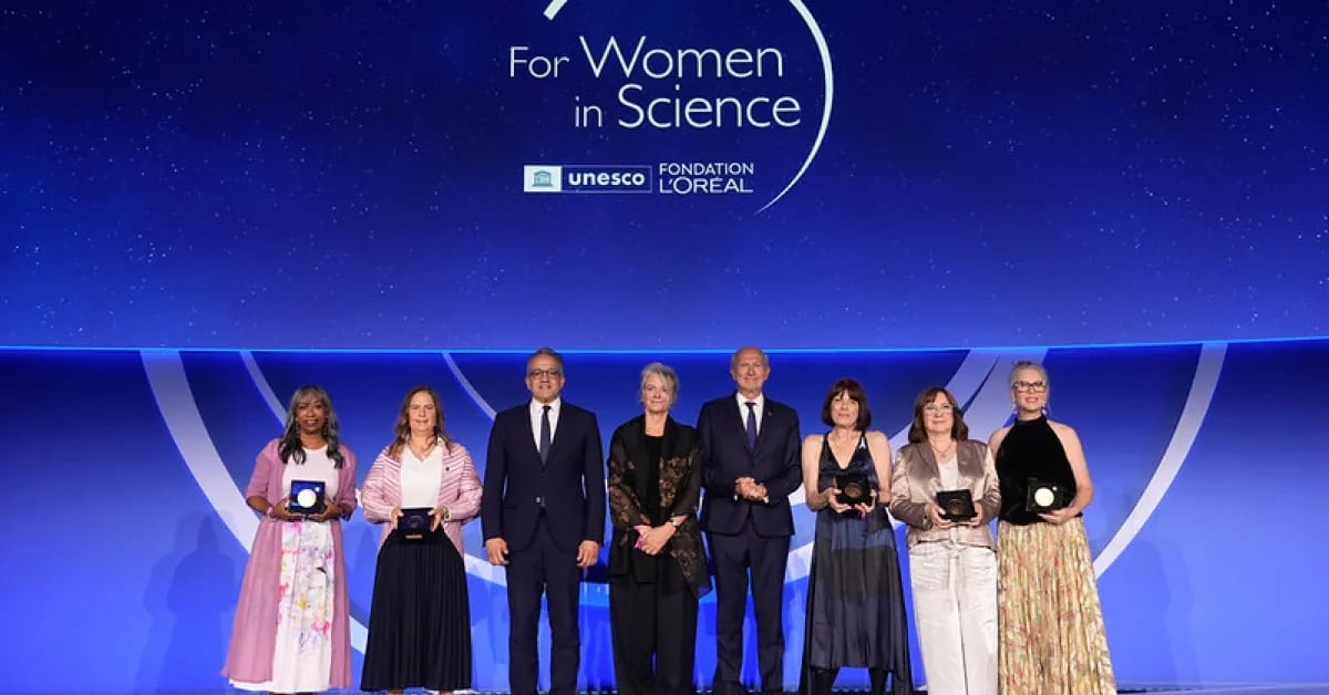 Five women scientists from different continents standing together at UNESCO ceremony in Paris