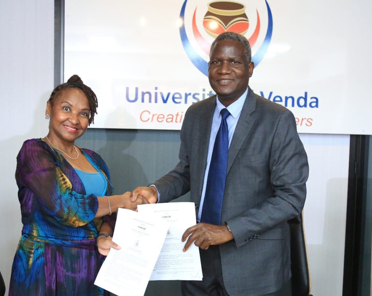University officials shaking hands at signing ceremony for technology partnership agreement in South Africa