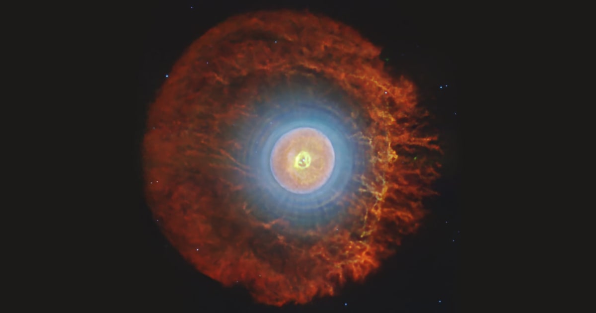 Colorful infrared image of planetary nebula Tc 1 showing glowing gas shells and filaments around dying star