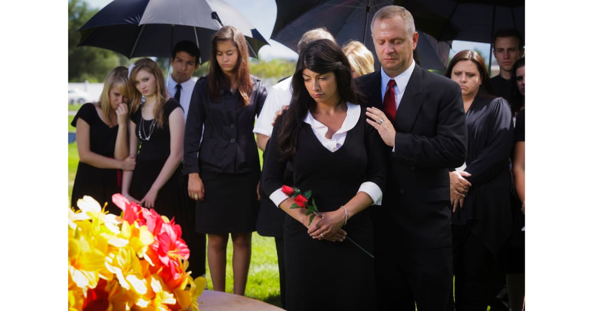 Family members laughing and crying at graveside during Shay Bradley's funeral in Dublin