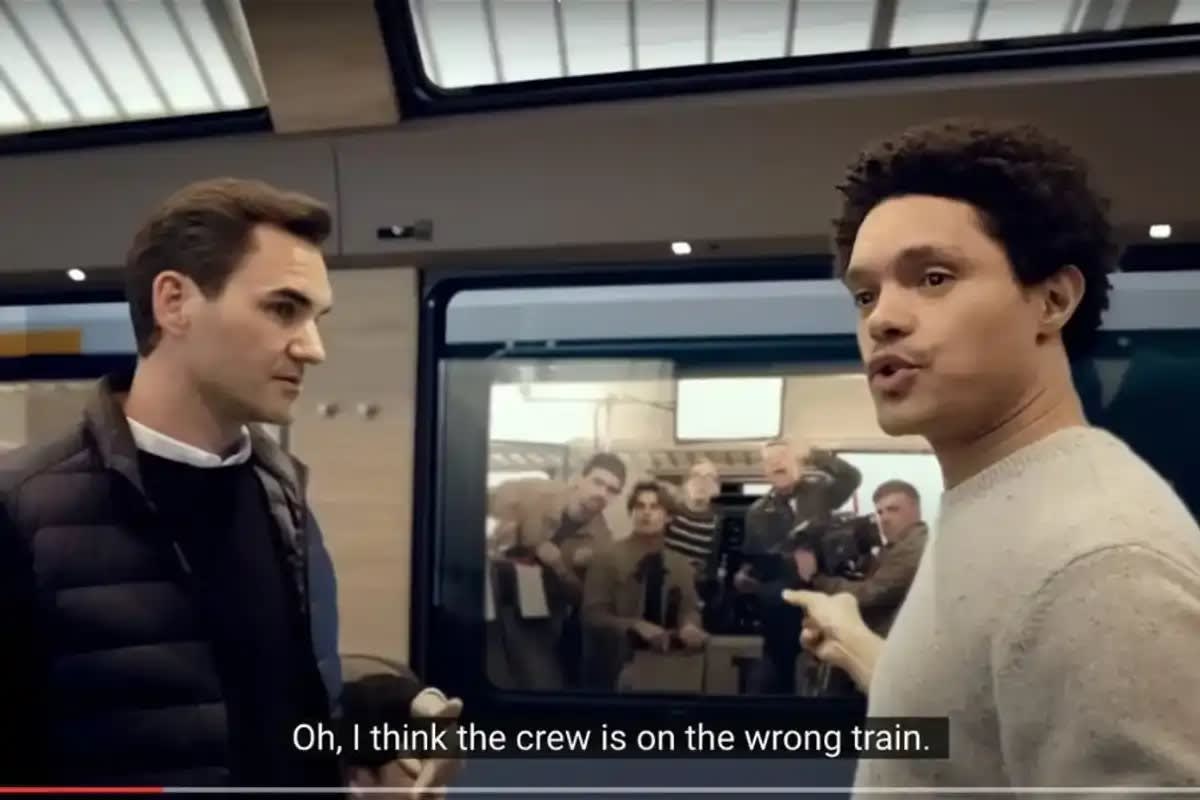 Trevor Noah and Roger Federer smiling together on a scenic Swiss train journey