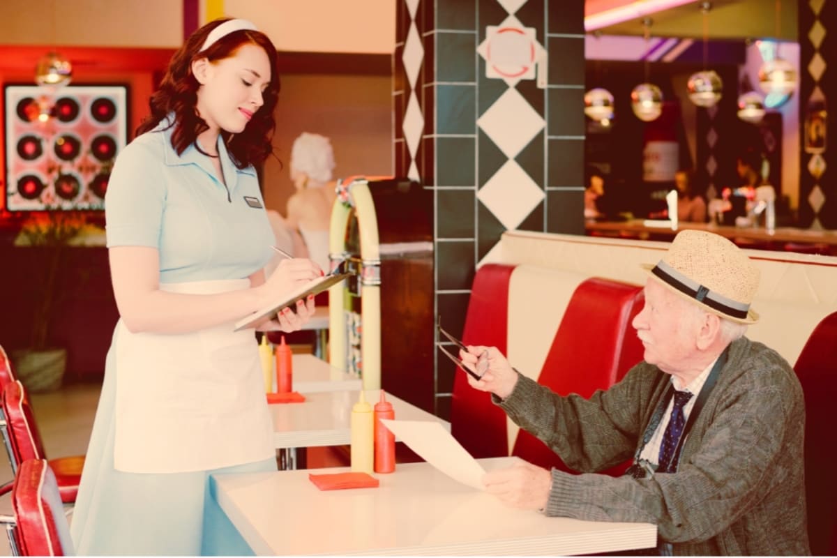 Elderly men sitting together in a 1950s-styled room with vintage furniture and decor