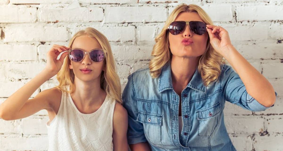 Mother and teenage daughter laughing together while spending quality time at home