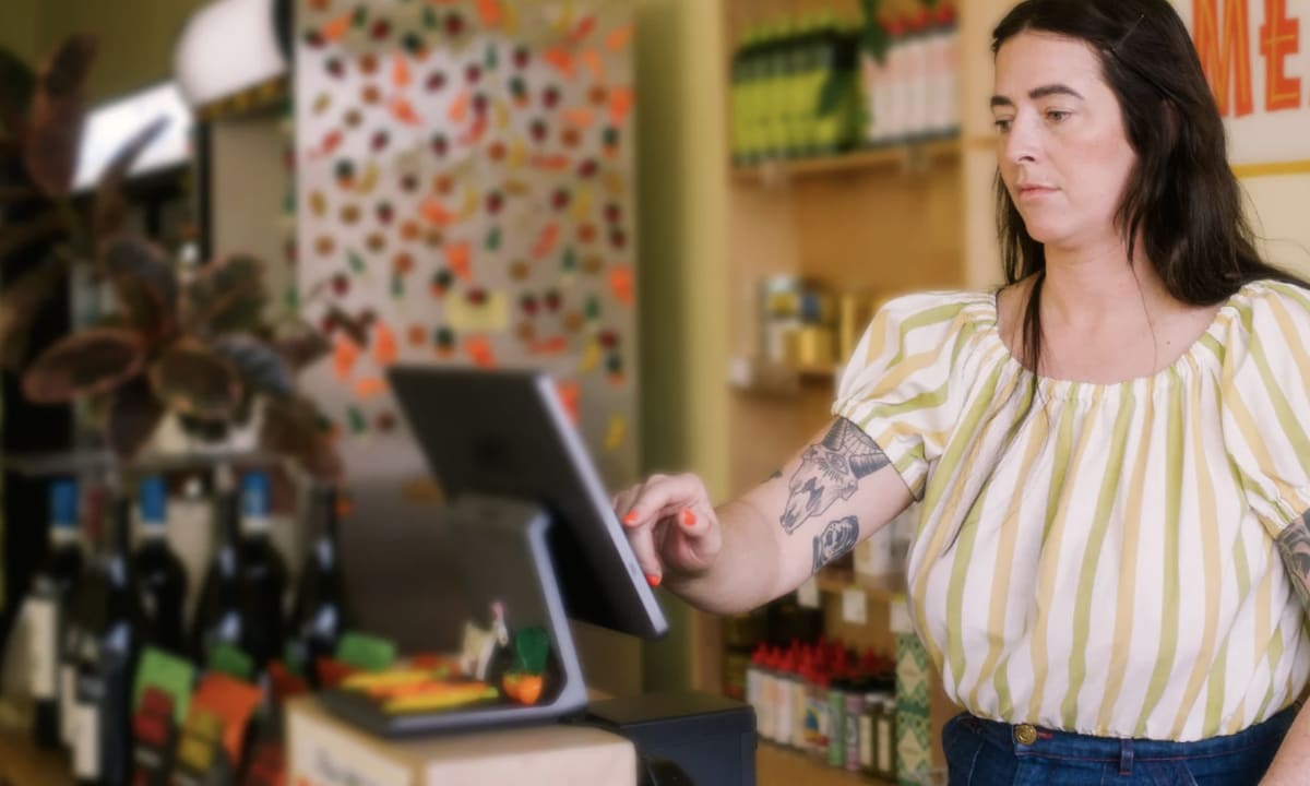 Subway restaurant employee behind counter serving customers during busy lunch service