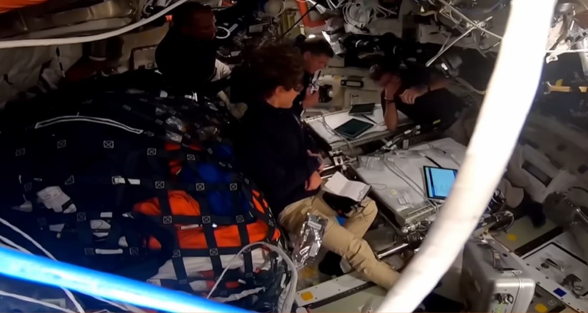 Four Artemis II astronauts embrace in emotional group hug inside spacecraft during Moon orbit