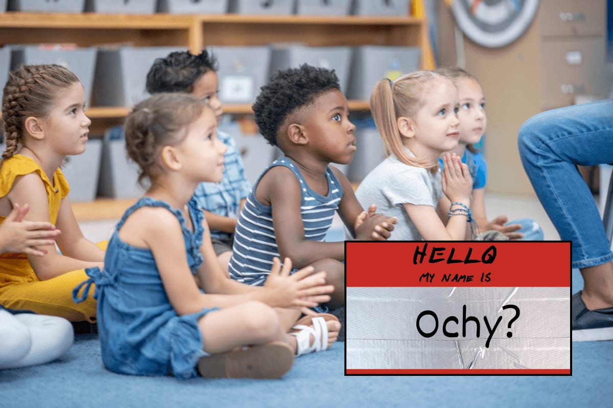 Kindergarten teacher holding name tag stickers while students choose their names for the day