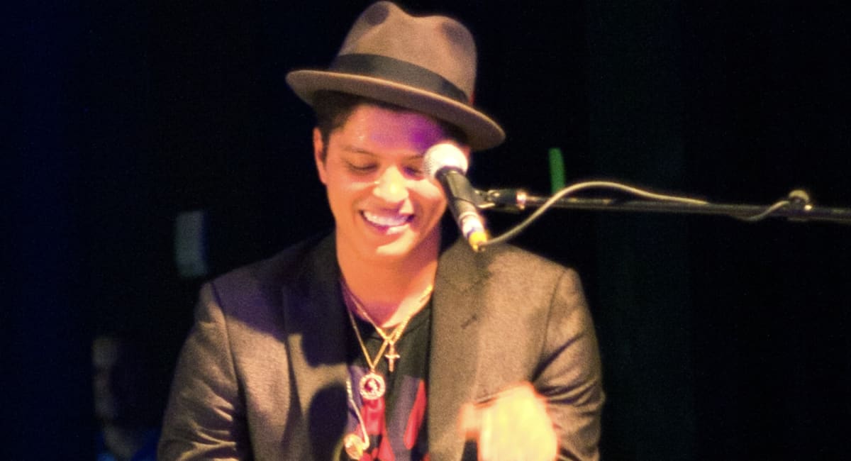 Bruno Mars in pink convertible waving to crowds during Las Vegas parade celebration