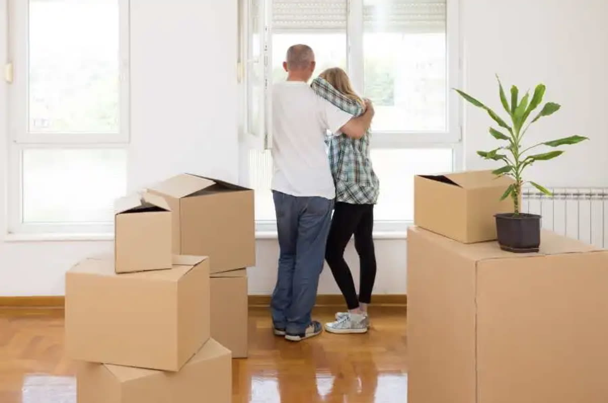 Empty room in family home with boxes packed for downsizing and moving