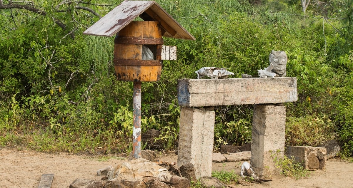 Wooden postal barrel on remote beach in Galapagos Islands with ocean backdrop
