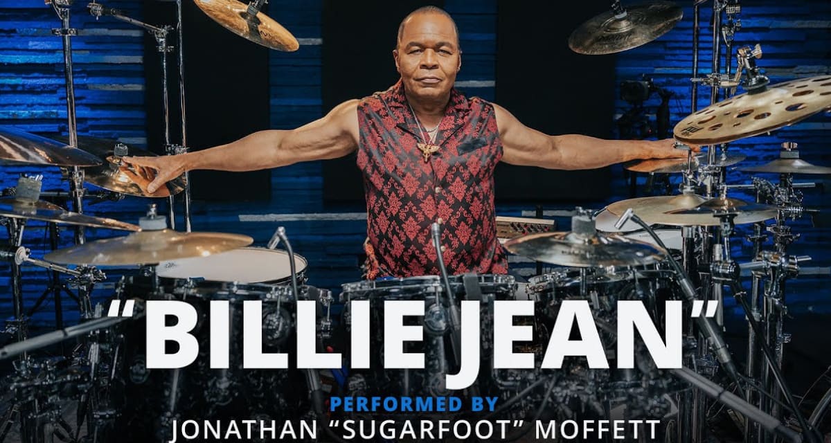 Jonathan Sugarfoot Moffett playing drums behind his glimmering silver drum kit during performance