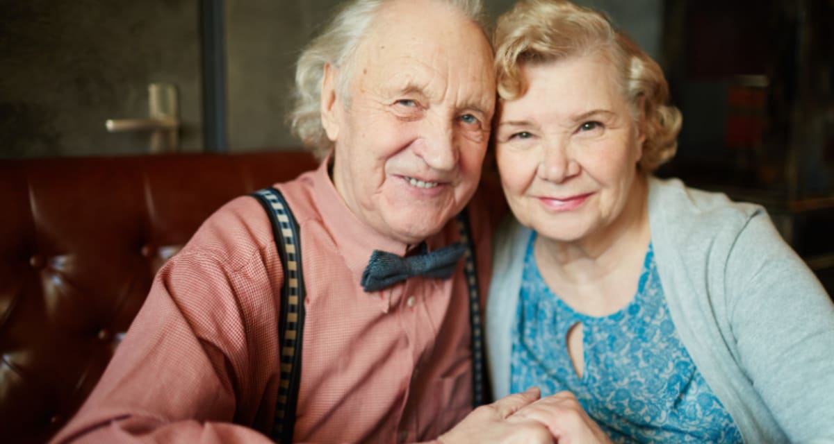 Elderly couple Betty and Kermit Eastman smiling together at their 80th wedding anniversary celebration
