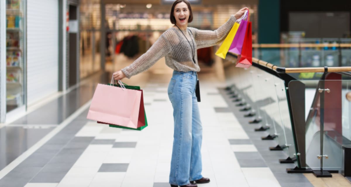 Group of young Gen Z shoppers walking through bright modern shopping mall together