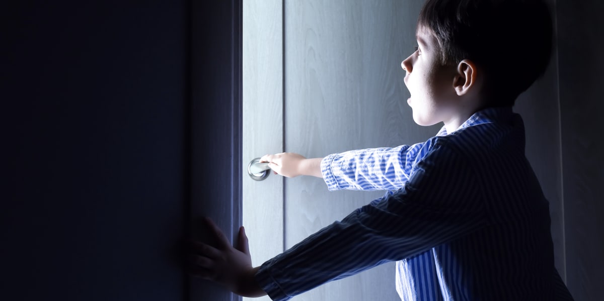 Young boy watching parent carefully, representing child learning emergency preparedness skills
