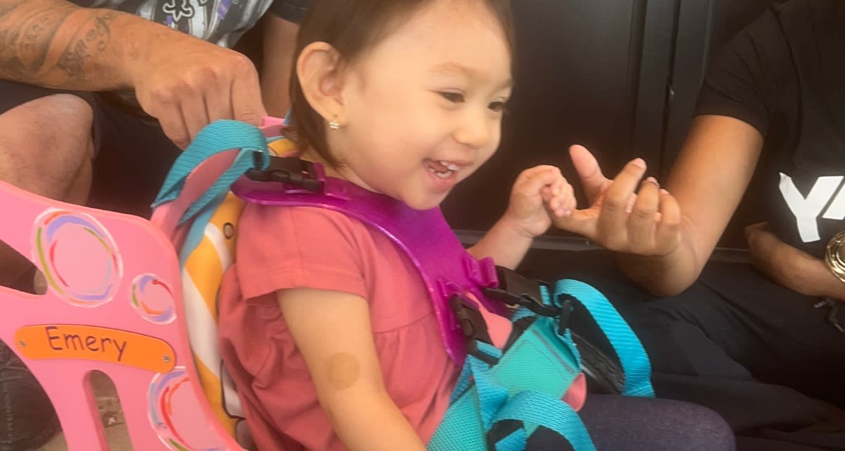Teen boy assembling colorful 3D printed wheelchair parts for toddler mobility device