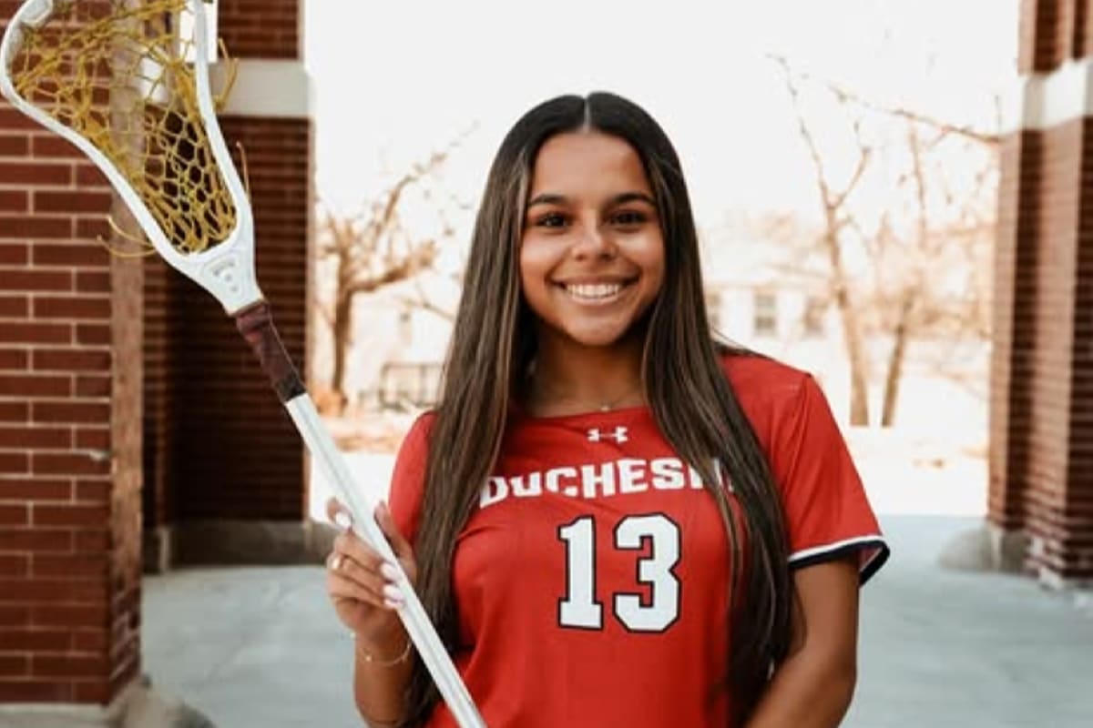 Young woman coaching elementary-age children in lacrosse on outdoor field in Omaha Nebraska