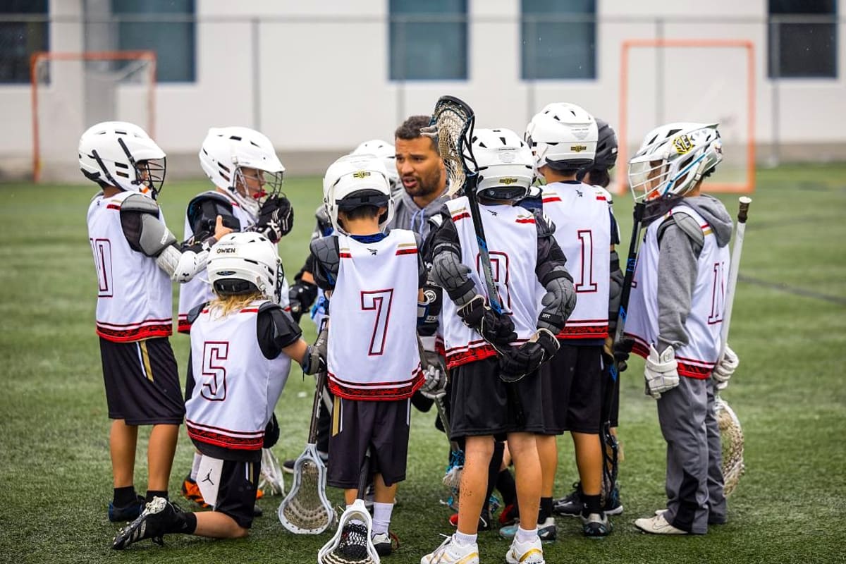 Youth lacrosse coach Dayton Gilbreath working with children on field in Los Angeles area