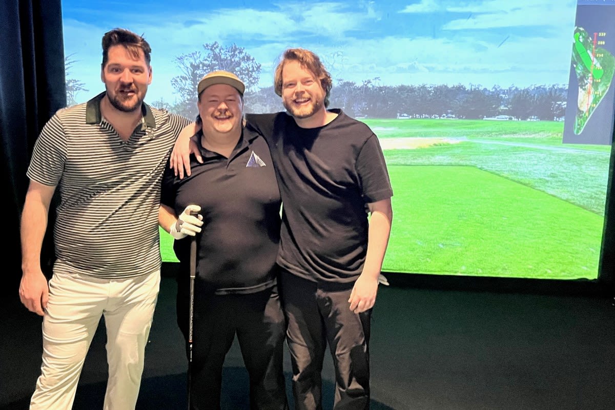 Golfers participating in virtual golf simulator tournament for charity fundraiser in Barrie