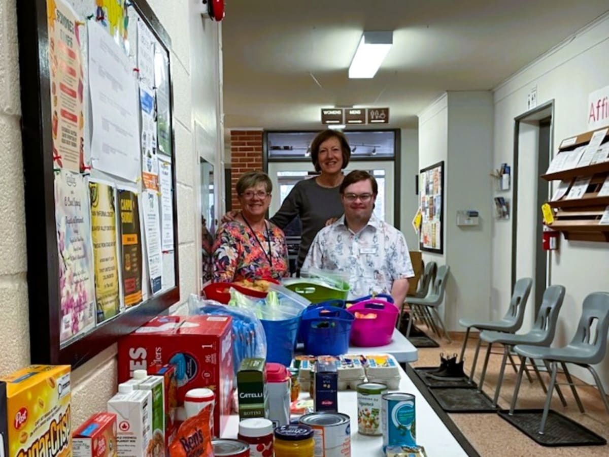 Senior woman volunteer organizing food donations at community church pantry in Collingwood