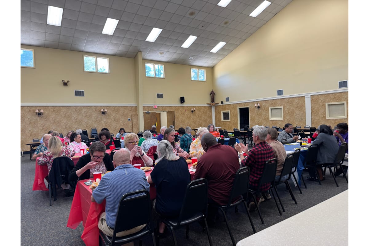 Cancer survivors embracing at community dinner celebrating resilience and shared healing journey