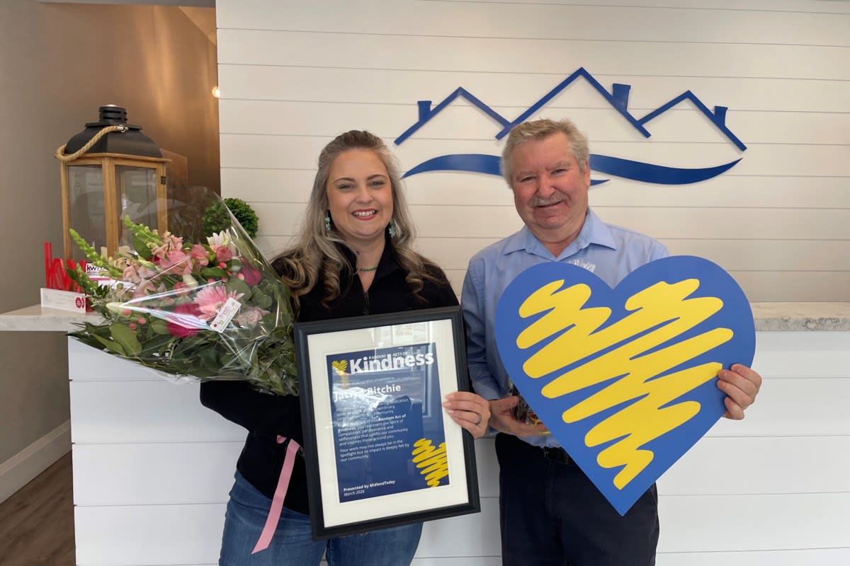 Jaclyn Ritchie smiling with her husband and sons during surprise recognition ceremony