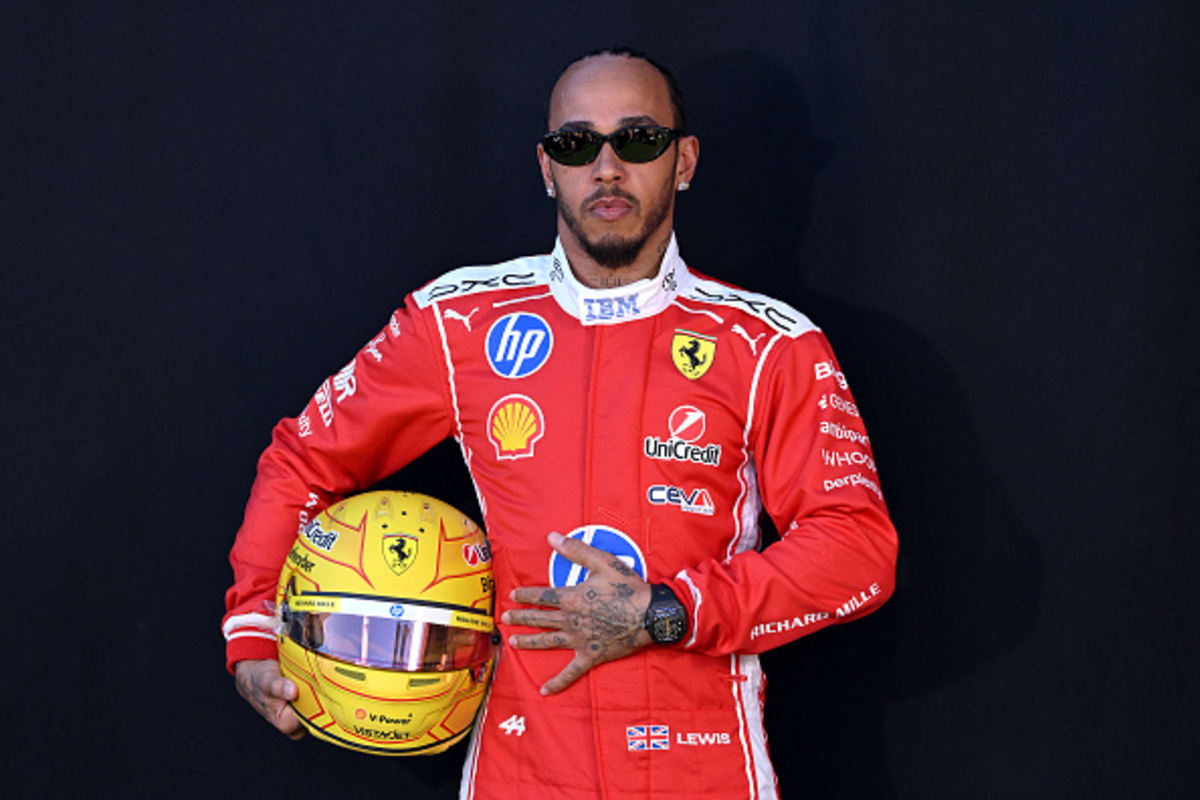 Lewis Hamilton celebrates on podium in Ferrari red after securing second place finish