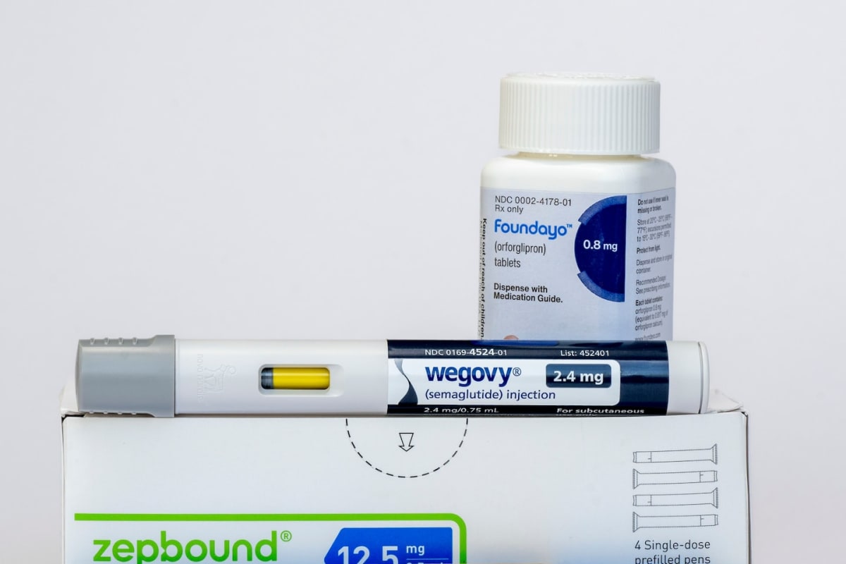Senior adult smiling while holding prescription medication bottle in pharmacy setting