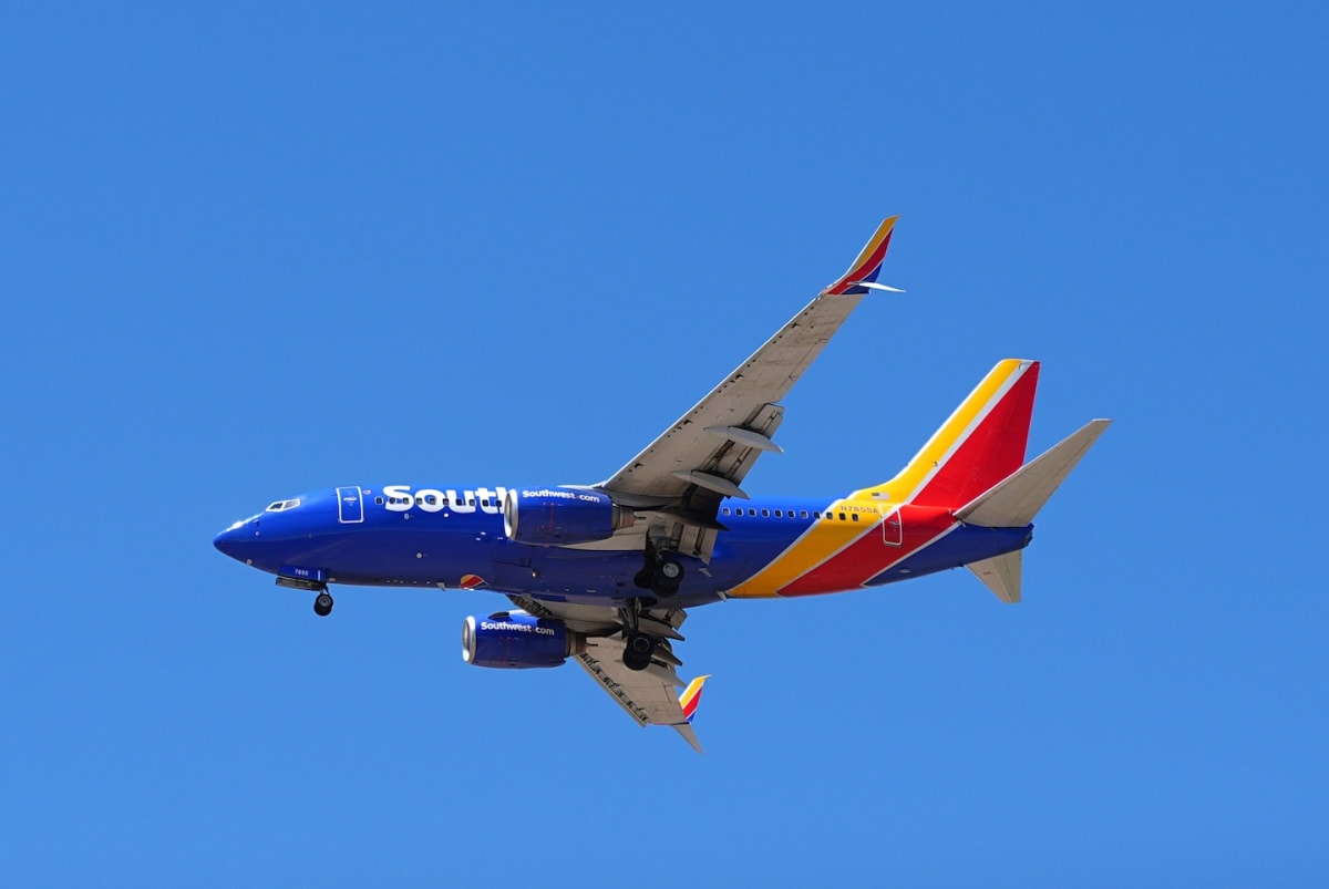 Southwest Airlines aircraft at airport gate with passengers boarding via jet bridge