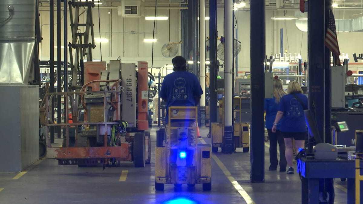 Manufacturing workers assembling recreational boats inside Tennessee production facility using AI-assisted tools