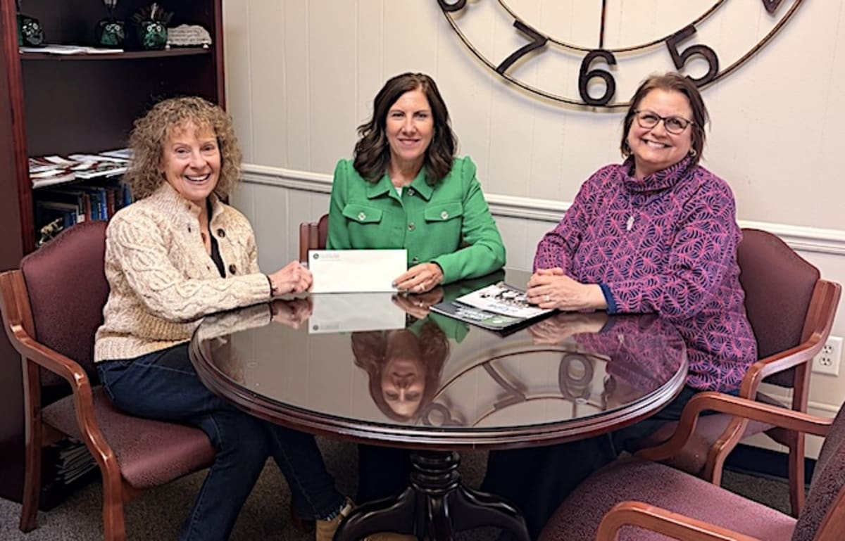 Three people standing together holding donation check for Next Chapter Scholarship Fund at Defiance Area Foundation