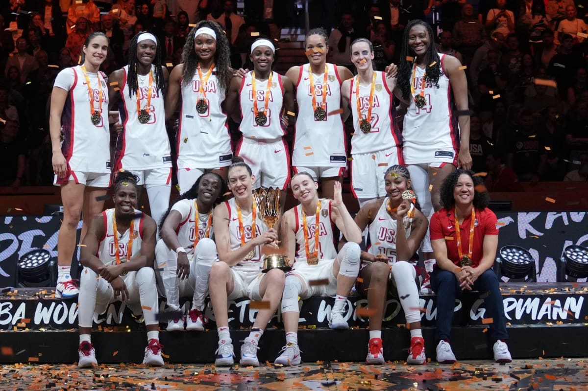 US women's basketball team celebrating on podium with gold medals after World Cup victory